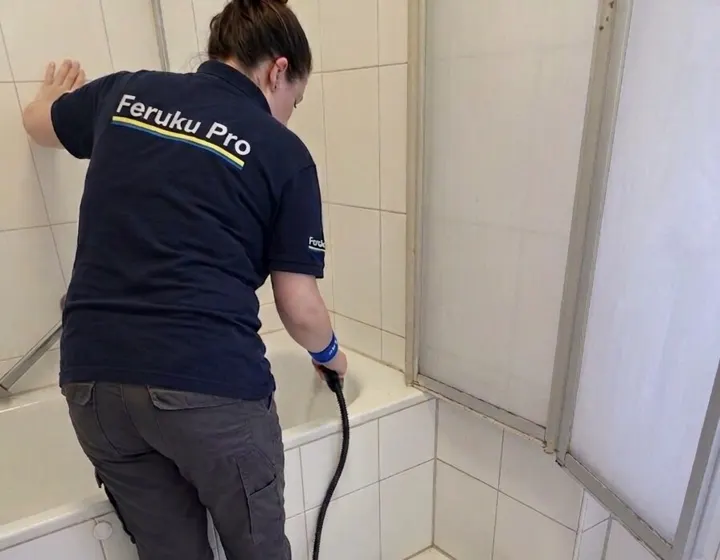 Mitarbeiterin von Feruku Pro reinigt ein Badezimmer mit dem Dampfreiniger